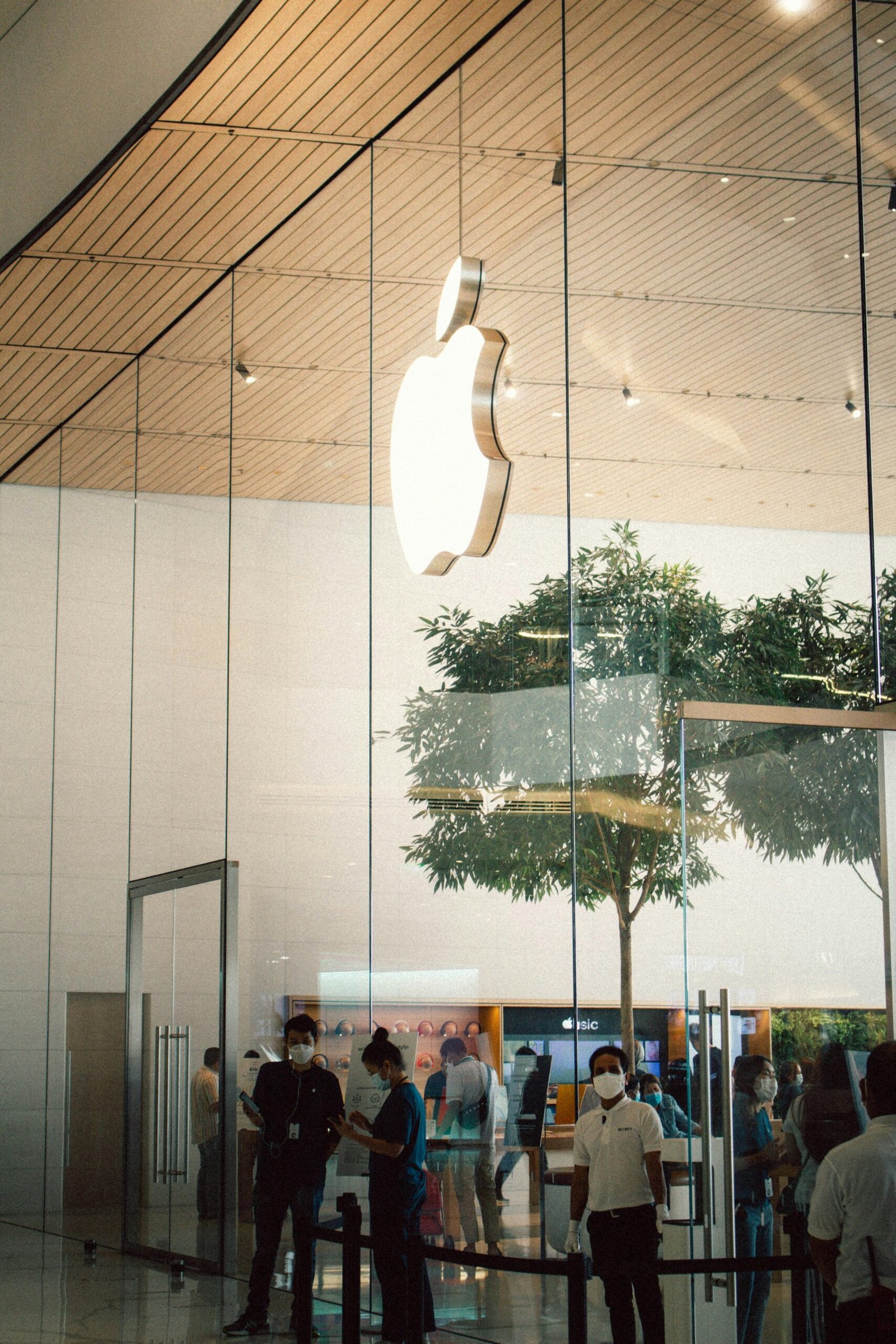 Apple Store entrance in Bangkok with people and glass architecture visible.